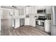Modern kitchen featuring stainless steel appliances, white cabinets, and an open view to the living space at 5505 Crabtree Park Ct, Raleigh, NC 27612