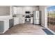 Bright kitchen with stainless steel appliances, white cabinets, and hardwood flooring, leads to a wooden deck at 5505 Crabtree Park Ct, Raleigh, NC 27612
