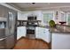 Modern kitchen with stainless steel appliances, granite countertops, and white cabinets at 600 Old Farm Rd Rd, Graham, NC 27253