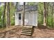 Charming backyard outbuilding with a welcoming door, surrounded by mature trees and greenery at 600 Old Farm Rd Rd, Graham, NC 27253