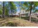 A well-maintained backyard with a wooden deck and mature trees offers a private and relaxing outdoor space at 613 Holly Thorn, Holly Springs, NC 27540