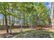 The backyard boasts mature trees and wooden deck, creating a serene outdoor retreat for relaxation and entertainment at 613 Holly Thorn, Holly Springs, NC 27540