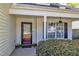 Inviting front porch with decorative door, manicured bushes, and a large window letting in natural light at 613 Holly Thorn, Holly Springs, NC 27540