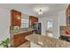Bright kitchen with wooden cabinets, granite countertops, stainless steel appliances, and hardwood floors at 613 Holly Thorn, Holly Springs, NC 27540