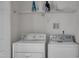 Functional laundry area with white washer and dryer, and organized shelving at 613 Holly Thorn, Holly Springs, NC 27540