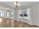 Bright living room featuring wood floors, white walls, and natural light from large windows at 613 Holly Thorn, Holly Springs, NC 27540