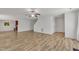 Open-concept living area with wood floors, staircase, ceiling fan, and abundant natural light at 613 Holly Thorn, Holly Springs, NC 27540
