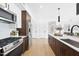 Open concept kitchen with stainless steel appliances, wood floors, and connects to the living space at 615 W Peace St # 201, Raleigh, NC 27605