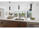 Bright kitchen island, white quartz countertop, with pendant lights, view to the living space and outdoors at 615 W Peace St # 201, Raleigh, NC 27605
