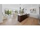 Open concept kitchen with wood floors, island, stainless steel appliances, pendant lights, and living space at 615 W Peace St # 201, Raleigh, NC 27605