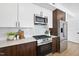 Modern kitchen featuring stainless steel appliances, white subway tile, white quartz countertop, and wood floors at 615 W Peace St # 201, Raleigh, NC 27605
