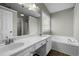 Bathroom featuring double sink vanity, soaking tub, and window with natural light at 616 Branchview Dr, Durham, NC 27713