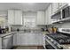 Modern kitchen with white cabinets, stainless steel appliances, and dark wood flooring at 616 Branchview Dr, Durham, NC 27713