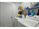 Bright laundry room features white appliances and shelving for storage at 616 Branchview Dr, Durham, NC 27713
