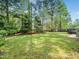 Backyard featuring lush green grass surrounded by trees at 6216 Valley Estates Dr, Raleigh, NC 27612
