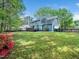 Spacious backyard featuring a well-maintained lawn, wooden fence, and charming blue house with a deck at 6216 Valley Estates Dr, Raleigh, NC 27612