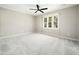 Empty bedroom features a ceiling fan, a large window, and neutral carpet at 6216 Valley Estates Dr, Raleigh, NC 27612