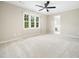 Empty bedroom features a ceiling fan, a large window, and neutral carpet at 6216 Valley Estates Dr, Raleigh, NC 27612