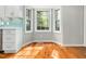 Bright breakfast nook featuring a bay window, hardwood floors, and white cabinets at 6216 Valley Estates Dr, Raleigh, NC 27612