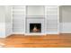 Cozy fireplace surrounded by built-in shelving in a well-lit living room with hardwood floors at 6216 Valley Estates Dr, Raleigh, NC 27612