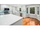 Modern kitchen with white cabinets, a large island, stainless steel appliances, and hardwood floors, bathed in natural light at 6216 Valley Estates Dr, Raleigh, NC 27612