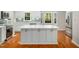 Bright kitchen with white cabinets, stainless steel appliances, a large island, and hardwood floors at 6216 Valley Estates Dr, Raleigh, NC 27612
