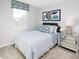 Serene bedroom featuring soft, blue accents, a mirrored nightstand, and comfortable striped bedding at 634 Silverado Sunset Loop, Wendell, NC 27591