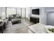 Spacious living area with gray sofas, a modern TV setup, and an open layout connecting to the kitchen and dining area at 634 Silverado Sunset Loop, Wendell, NC 27591