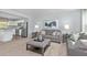 Bright living room blends seamlessly with the modern kitchen, featuring stylish gray furniture and contemporary decor at 634 Silverado Sunset Loop, Wendell, NC 27591