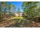 Large, fenced backyard with mature trees and a playset, perfect for outdoor activities and entertaining at 7221 Messenger Dr, Willow Springs, NC 27592