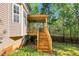 A spacious wooden deck with stairs offers a relaxing outdoor space with a view of the lush backyard at 7221 Messenger Dr, Willow Springs, NC 27592