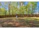 Backyard featuring a playset, wooden fence, and mature trees offers a private and Gathering-friendly outdoor space at 7221 Messenger Dr, Willow Springs, NC 27592