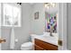 A quaint bathroom featuring a single sink vanity, toilet, and window with natural light at 7221 Messenger Dr, Willow Springs, NC 27592