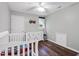 A cozy bedroom with a white dresser, dark floors, and a crib offers a comforting space for sleep and relaxation at 7221 Messenger Dr, Willow Springs, NC 27592