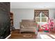 A Bedroom room with a crib, chalkboard wall, and wood floors offers a welcoming and cozy space at 7221 Messenger Dr, Willow Springs, NC 27592