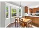 Cozy dining area featuring a wooden table set, bathed in natural light from large windows, complementing the hardwood flooring at 7221 Messenger Dr, Willow Springs, NC 27592