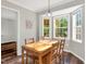 Charming dining area with a wooden table set, enhanced by natural light streaming through bay windows and hardwood floors at 7221 Messenger Dr, Willow Springs, NC 27592