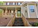 Inviting covered front porch with wooden railings and brick stairs leading up to the entrance at 7221 Messenger Dr, Willow Springs, NC 27592