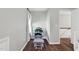 Hallway with a rocking chair, hardwood floors, and access to a bedroom creates a cozy and inviting space at 7221 Messenger Dr, Willow Springs, NC 27592