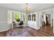 Bright home office featuring a desk setup by a bay window, complemented by a chandelier and hardwood flooring at 7221 Messenger Dr, Willow Springs, NC 27592