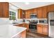 Well-equipped kitchen featuring stainless steel appliances, wooden cabinets, and a sink beneath a window at 7221 Messenger Dr, Willow Springs, NC 27592