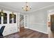 Inviting living area with hardwood floors, a cozy chandelier, and a staircase visible through glass doors at 7221 Messenger Dr, Willow Springs, NC 27592