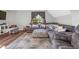 Cozy living room featuring a large sectional sofa, patterned ottoman, and natural light from the window at 7221 Messenger Dr, Willow Springs, NC 27592