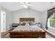 Spacious bedroom with a wooden bed frame, soft lighting, and matching side tables at 7221 Messenger Dr, Willow Springs, NC 27592