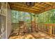 Inviting covered porch with a wood ceiling fan and two wooden rocking chairs that offers a peaceful outdoor retreat at 7221 Messenger Dr, Willow Springs, NC 27592