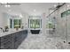 Modern bathroom featuring marble floors, black soaking tub, glass-enclosed shower, and a dual sink vanity at 7436 Summer Tanager Trl, Raleigh, NC 27614