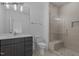 Bathroom featuring a gray vanity, tiled shower with a glass door, and modern fixtures at 7436 Summer Tanager Trl, Raleigh, NC 27614