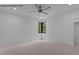 A modern bedroom with neutral carpeting, black framed windows, and a ceiling fan at 7436 Summer Tanager Trl, Raleigh, NC 27614