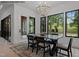 Dining area with modern chandelier, large windows overlooking backyard, and access to the patio at 7436 Summer Tanager Trl, Raleigh, NC 27614
