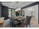 Dining room featuring modern chandelier, dark accent wall, and white trim at 7436 Summer Tanager Trl, Raleigh, NC 27614